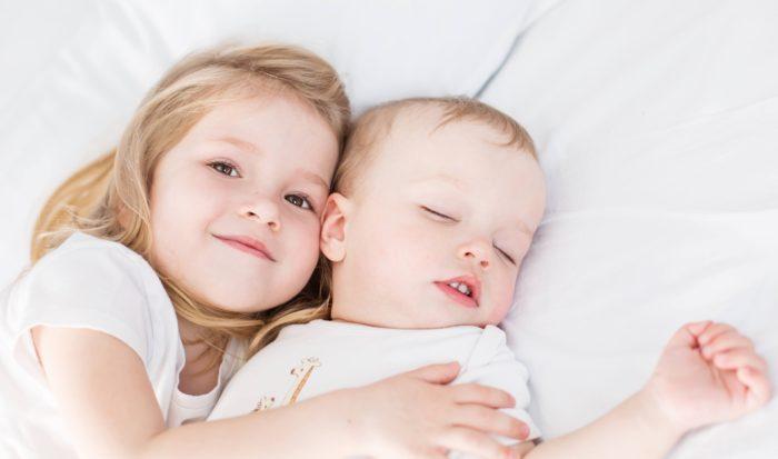 Opciones para el cuidado de niños, niña abrazando a su hermano bebé
