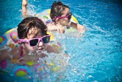 niños nadando en piscina con flotador