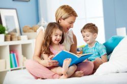 Cómo ser una buena cuidadora de niños, niñera leyendo cuento a dos hermanos