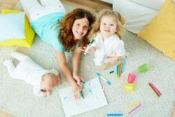 ¿Qué hacer para trabajar de niñera? Canguro con bebé y niña pintando