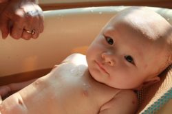 Una buena niñera de bebés baña al niño de forma segura