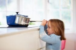 Cómo evitar accidentes infantiles, niña coge cazo en la cocina