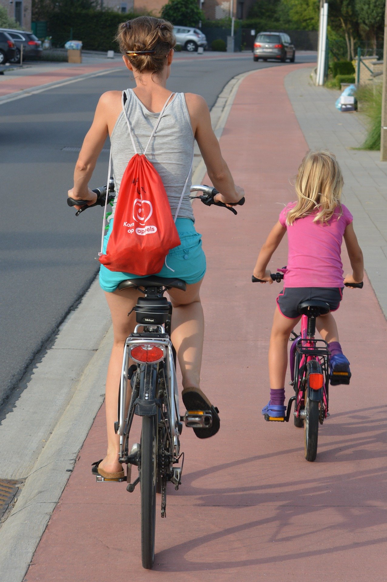 Niña y madre yendo por carril bici con bicicletas