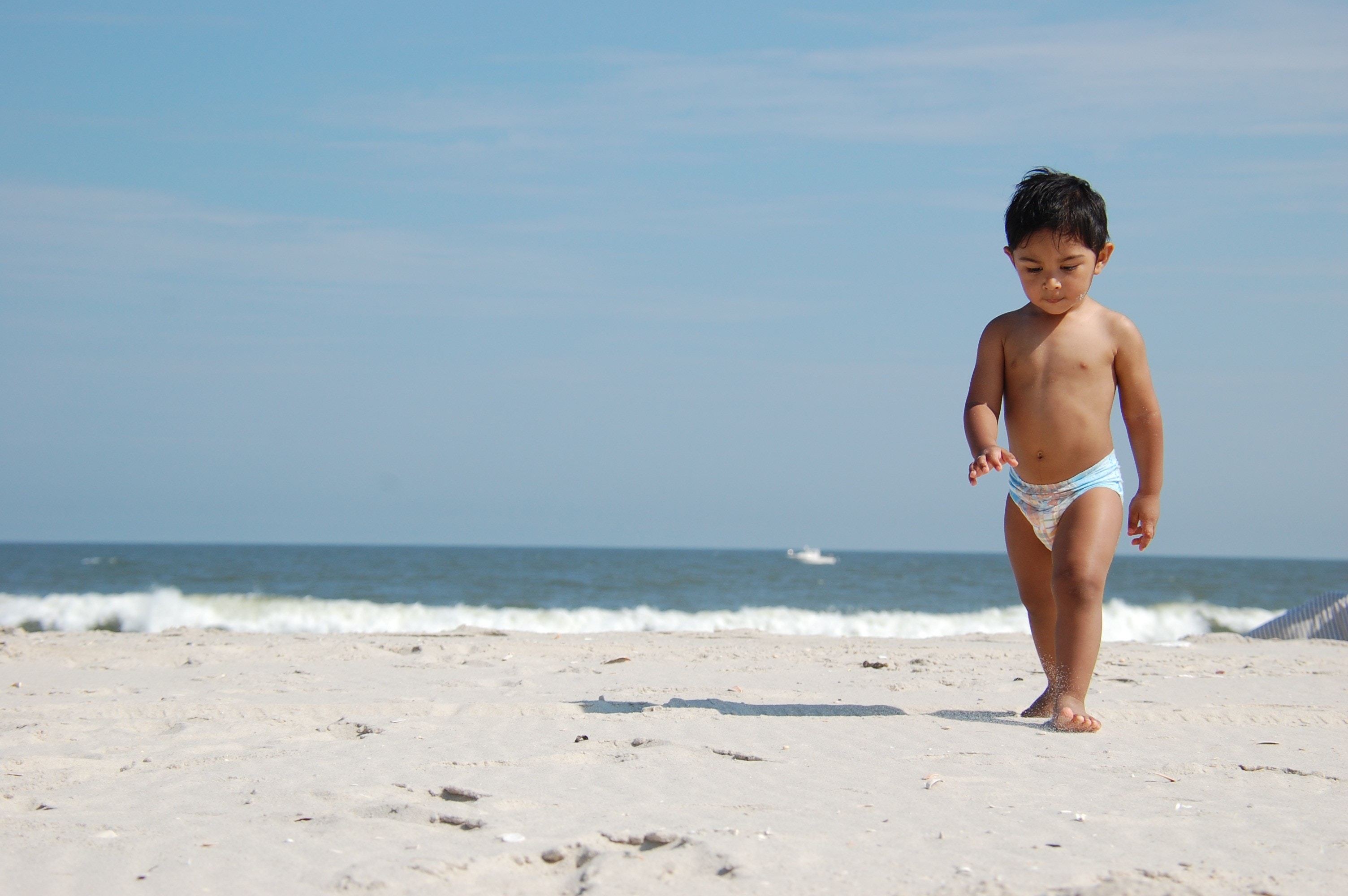 Niño caminando por la playa en fase de dejar el pañal
