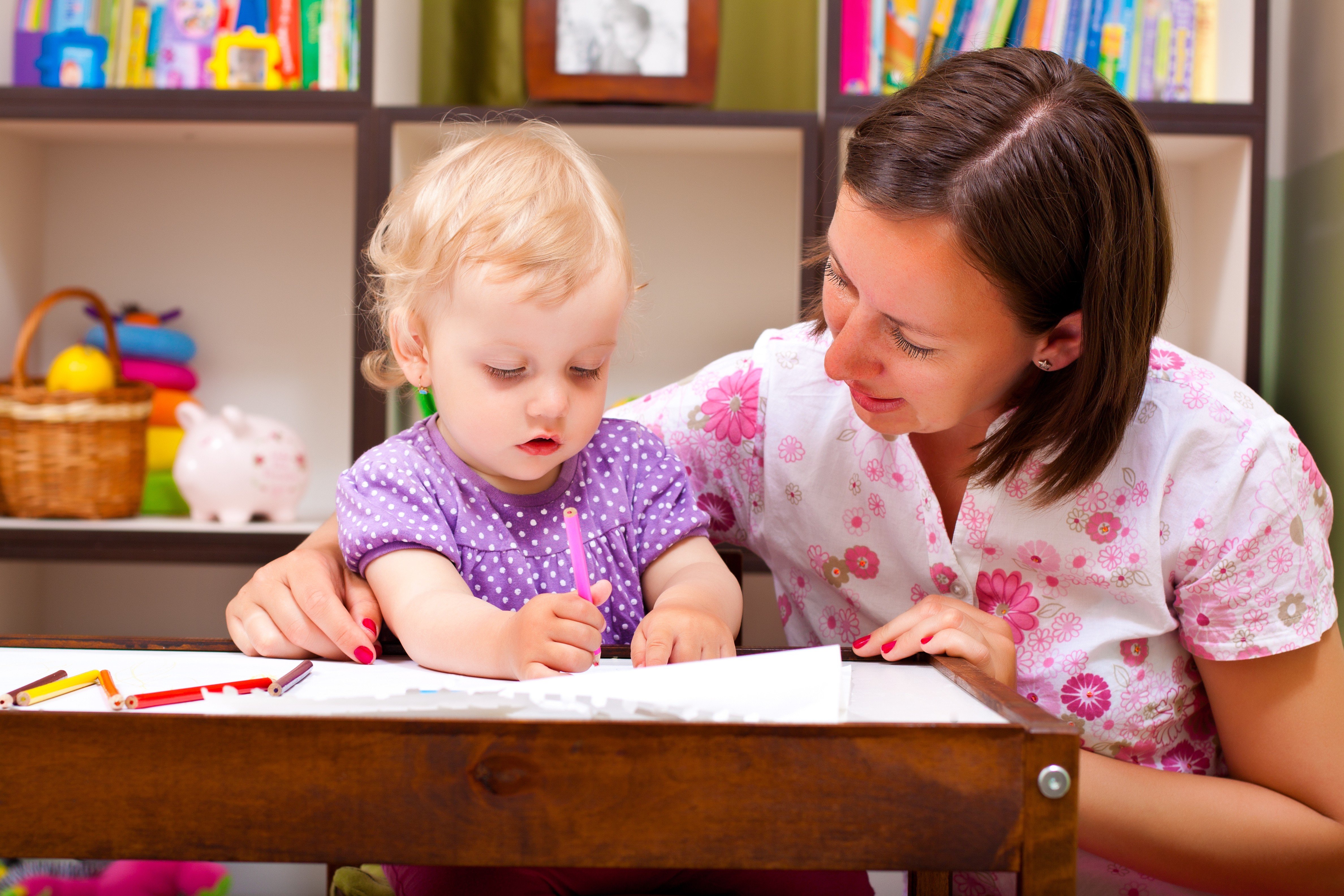 bambina disegna vicino alla baby sitter nonni nido o baby sitter