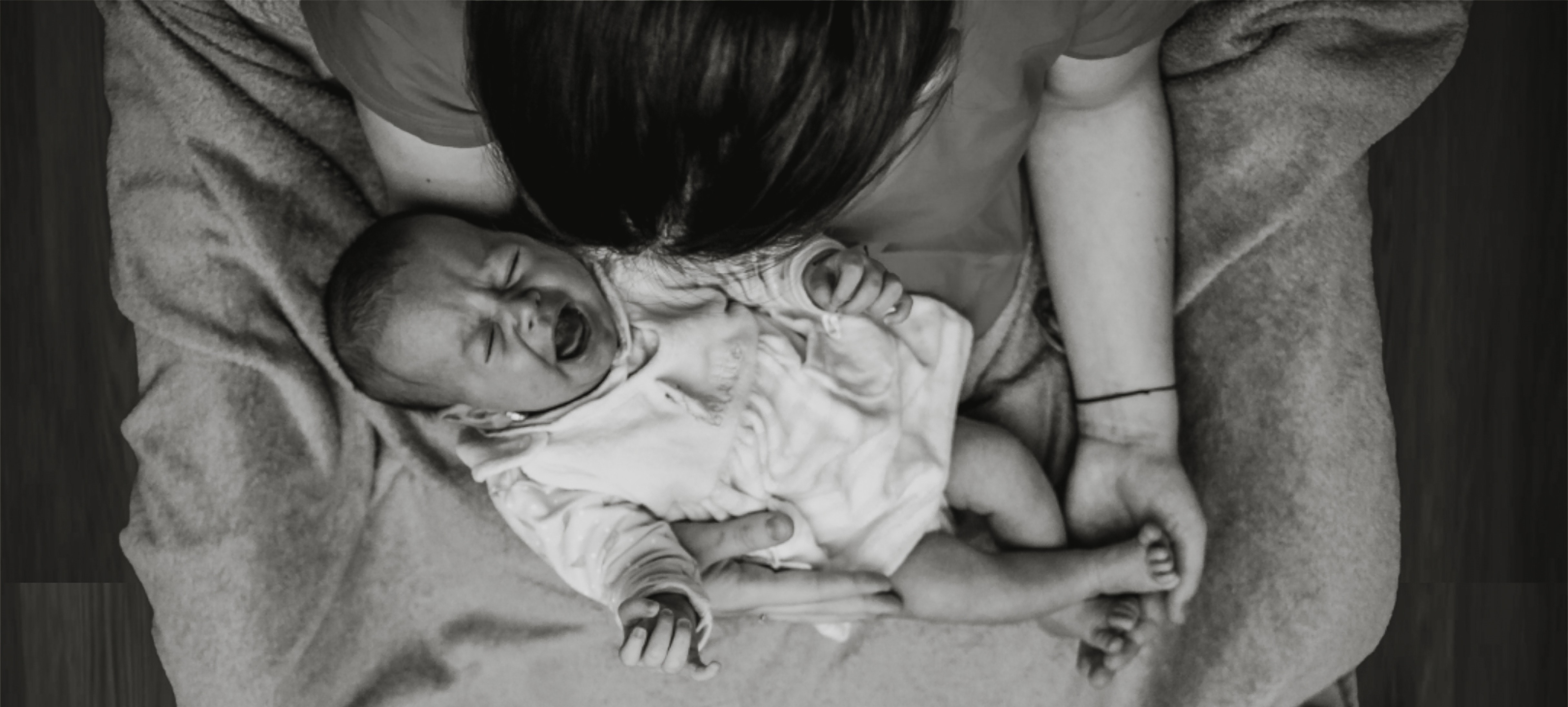 neonato piange in braccio alla mamma