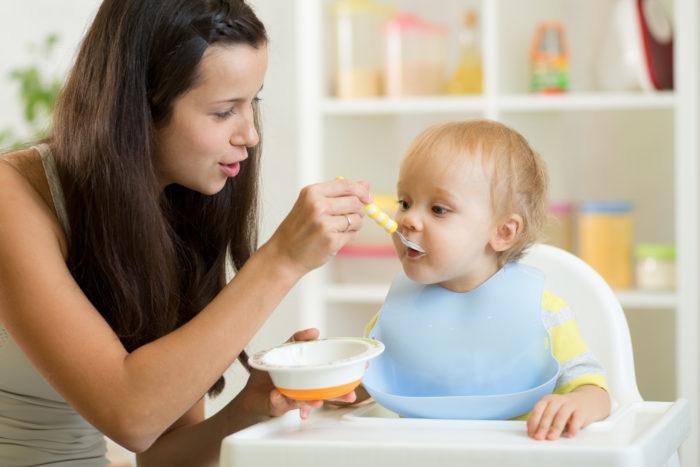 oppassen op een baby, baby eten geven