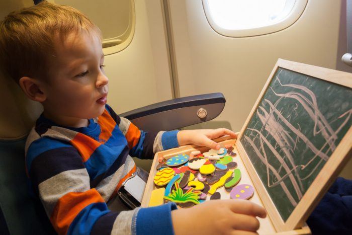 kind in het vliegtuig, spelen met krijt